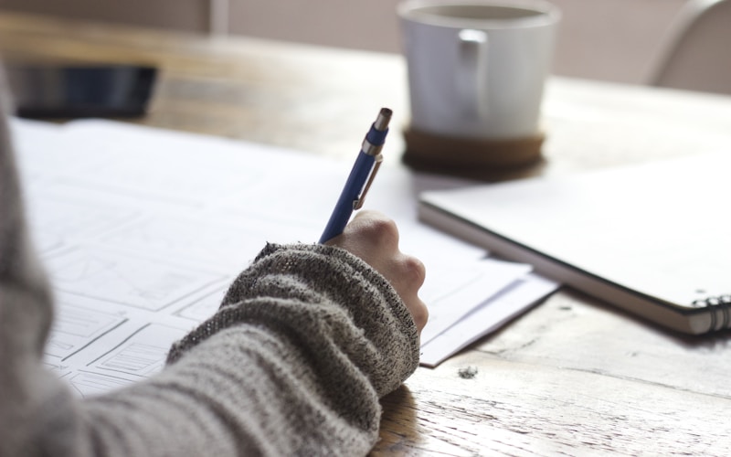 Notes being written beside a coffee cup during a working session